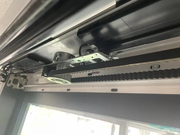 Sliding door operator with the cover off during an automatic door service